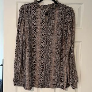 Large animal print blouse with ruffled collar and poofy sleeves.